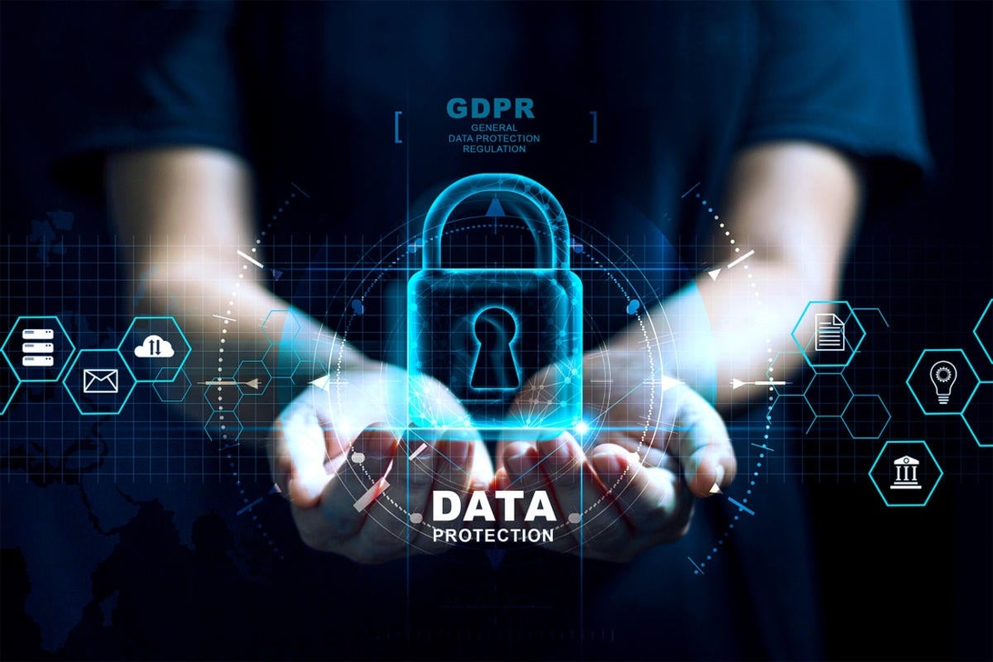 Digital bildkomposition som visar händer som håller en holografisk projektion av ett hänglås med texten 'GDPR' ovanför och 'DATA PROTECTION' under, omgivet av digitala ikoner som symboliserar data.